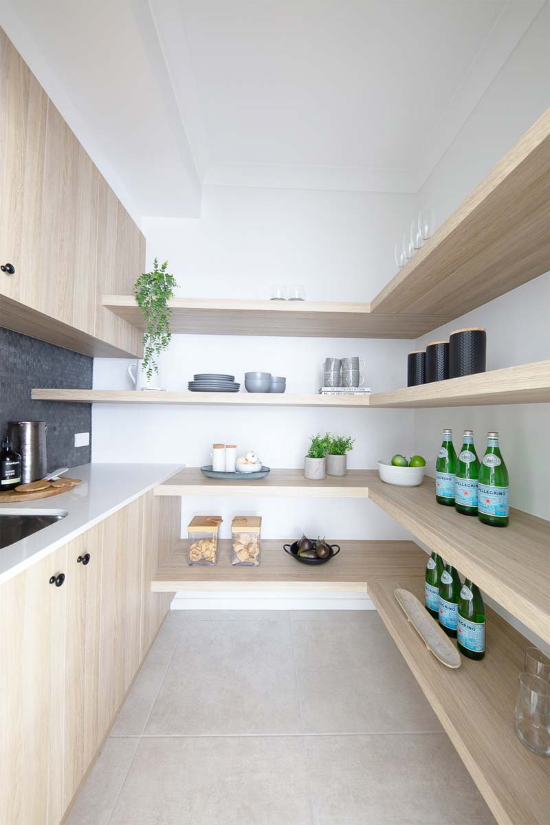 Deze praktische bijkeuken die een keukenblok met wastafel combineert met wandkasten en open planken, is ontworpen door Mc Carthy Homes