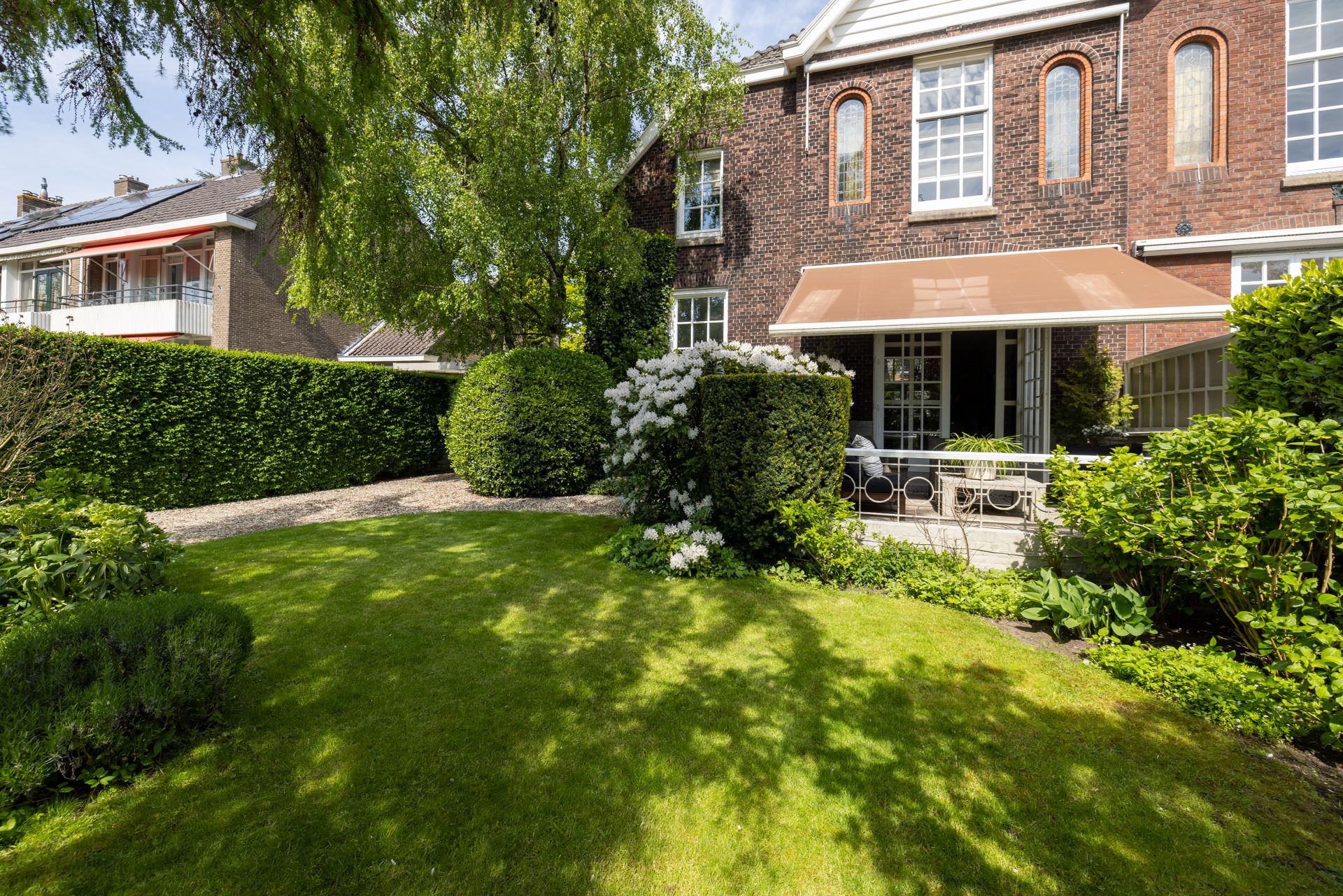 Een plantenborder met veel groen in een grote romantische tuin.