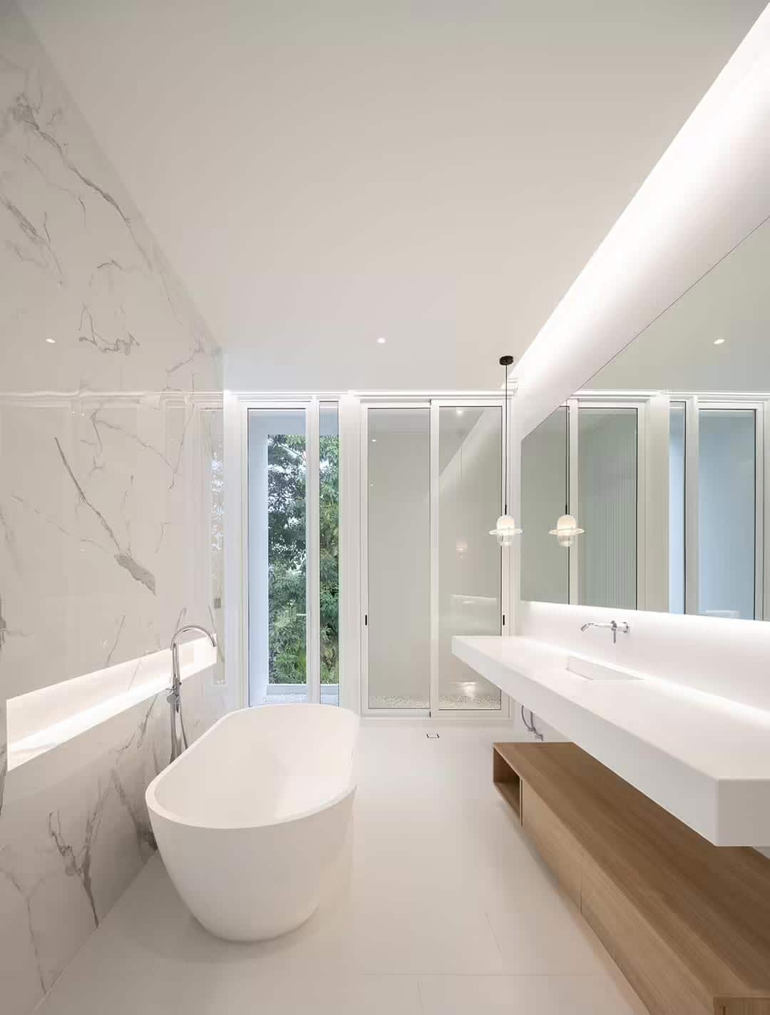 Pongpat Architect creëerde een luxe met marmer beklede scheidingswand, die de douche van het bad scheidt. 
