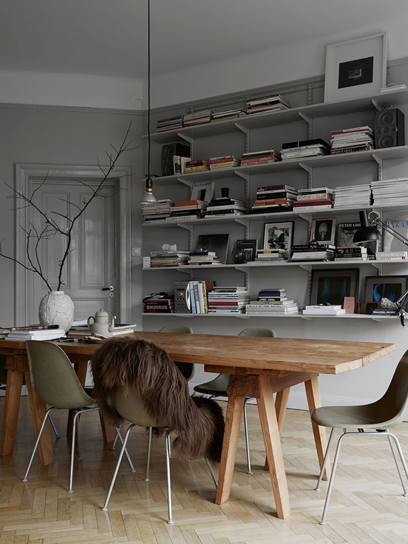 De open boekenplanken in deze eethoek zijn stijlvol nonchalant gestyled met boeken, magazines en andere mooie spullen.