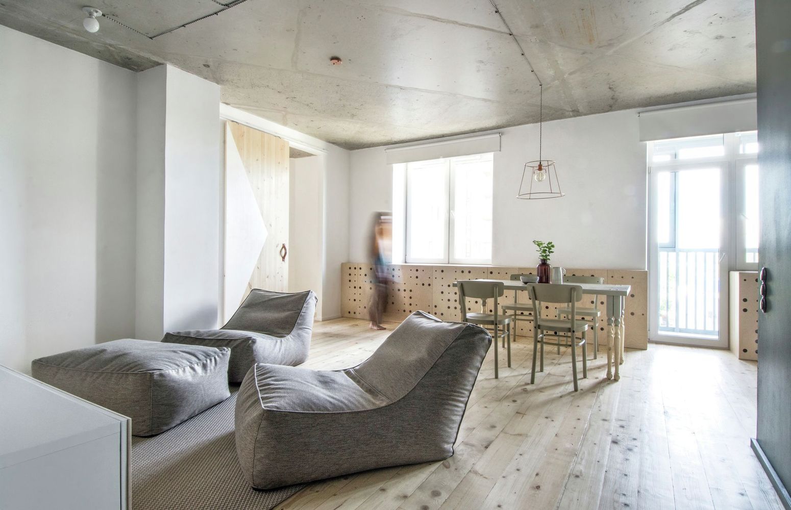 INT2architecture heeft dit stoere industriele interieur ontworpen voor een modern appartement. In de woonkamer hebben ze gekozen voor een op maat gemaakte vensterbank boekenkast van underlayment, die volledig afgesloten kan worden met speelse deurtjes.